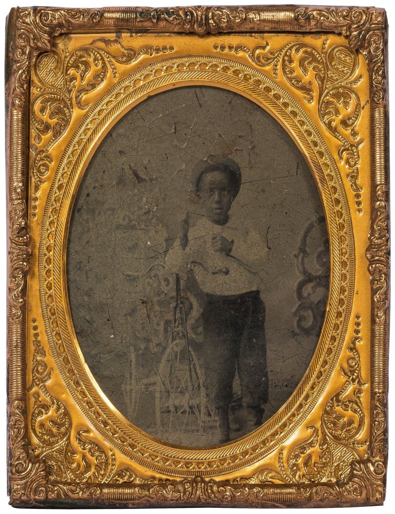 Item #604039 [Tintype photograph]: Young African-American Boy with Tricycle and Straw Hat